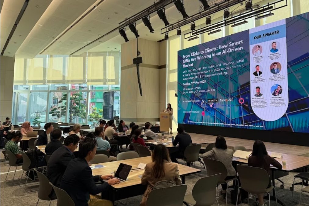 Workshop room with a large projected screen and participants seated in rows